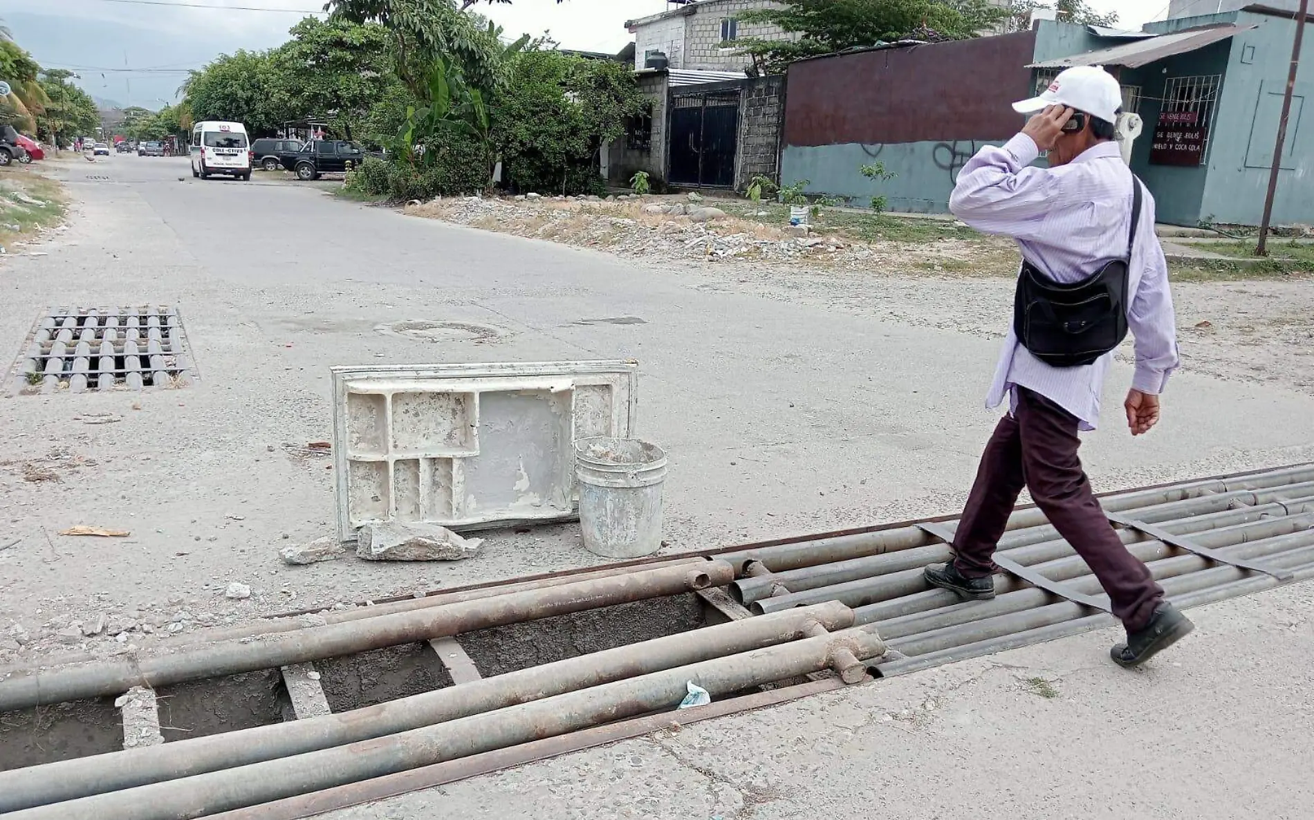 persona caminando por alcantarilla en mal estado